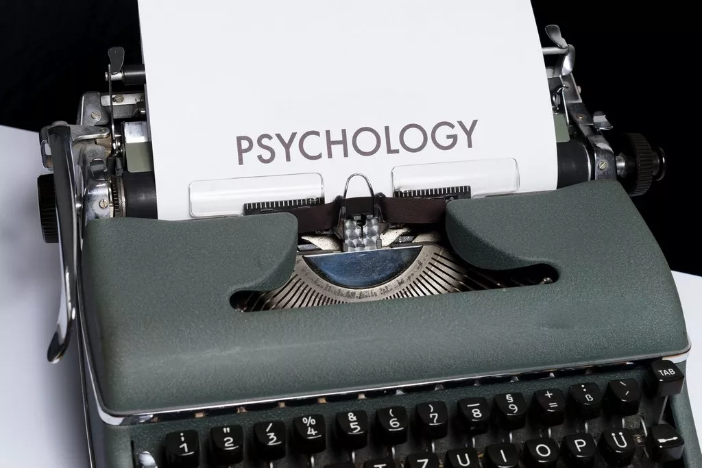 Una máquina de escribir con una hoja de un artículo de psicología.