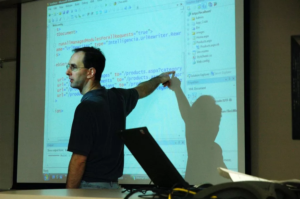 Man explaining code on a white board.